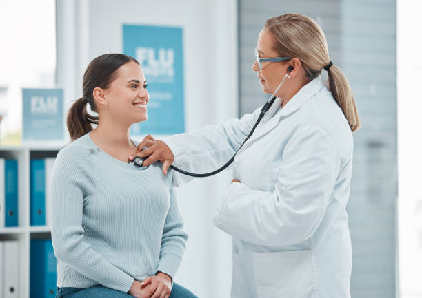 physical health - a doctor listening to a woman's heartbeat