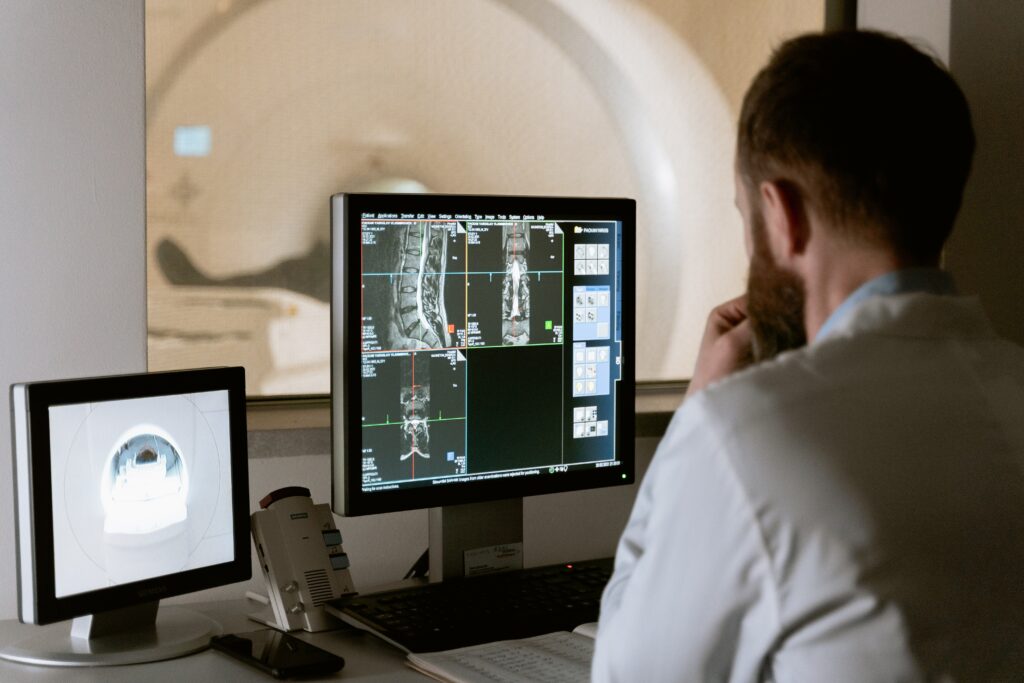 A doctor looking at two computers getting ready to have a Zoom meeting.