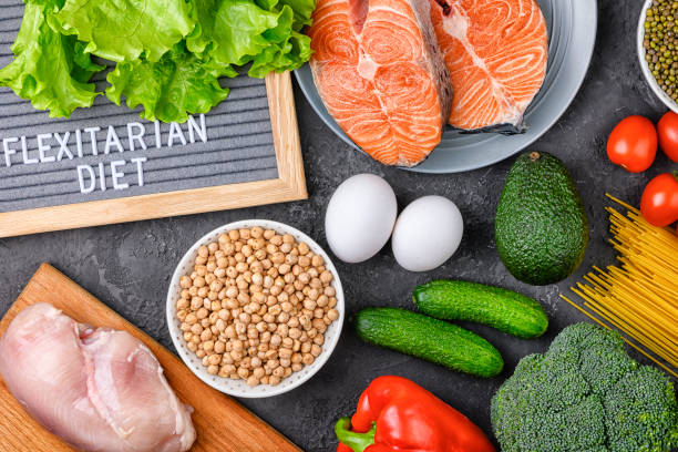 A set of products for a flexible diet. Salmon steak, chicken, chickpeas, mung beans and vegetables on a black background.