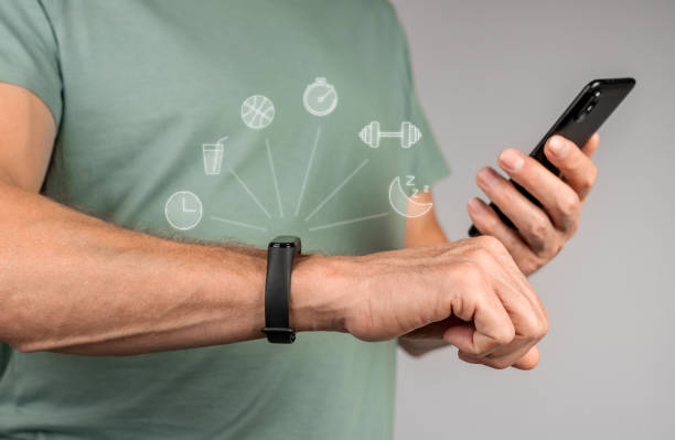 fitness bracelet and mobile phone. Hands with sport smartwatch and holding smartphone for sync. High quality photo