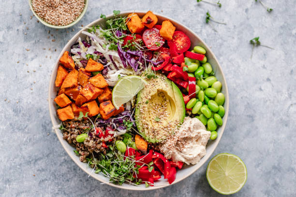 Vegan Diet - Overhead view of a colourful vegan bowl with quinoa, sweet potato, avocado, hummus and variety of veggies
