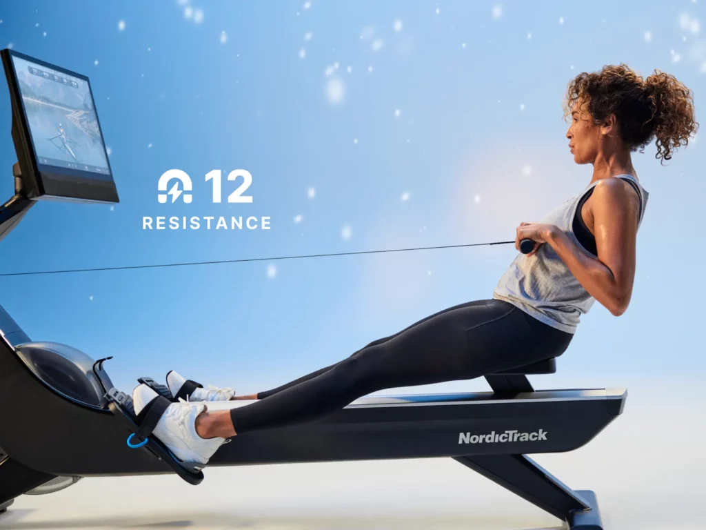 A woman on a NordicTrack Rowing machine with a screen and she is fully extended